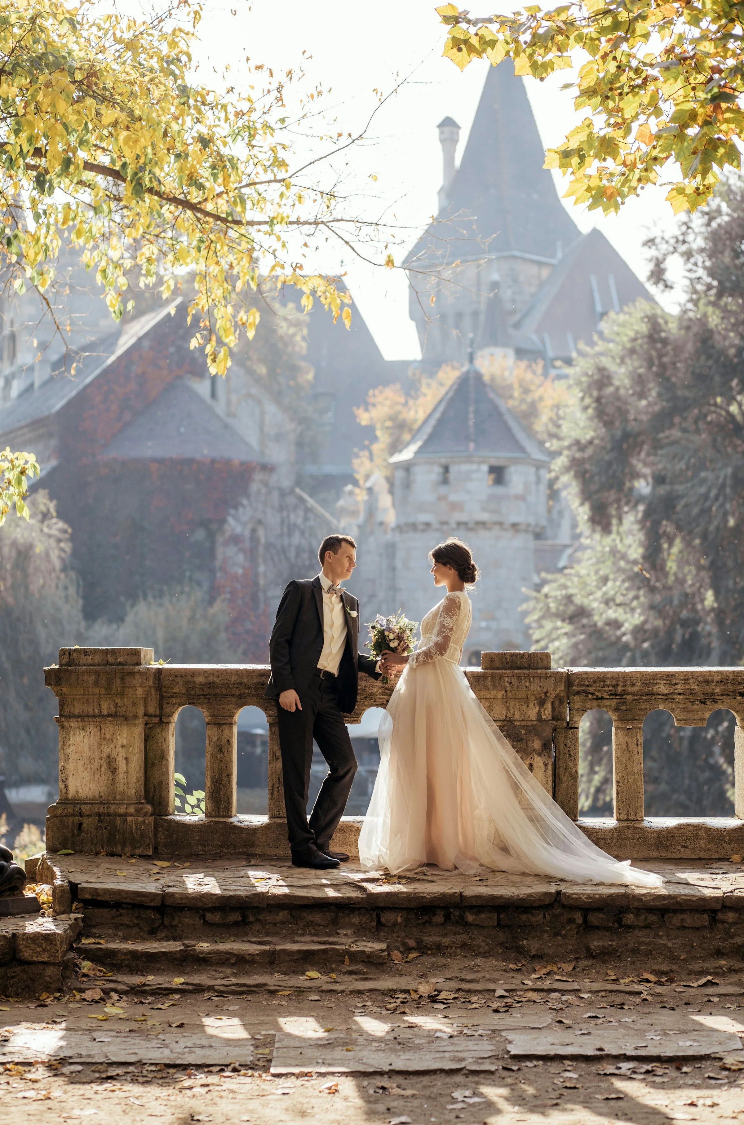 Newlyweds share a romantic dance under the evening sky, surrounded by guests.