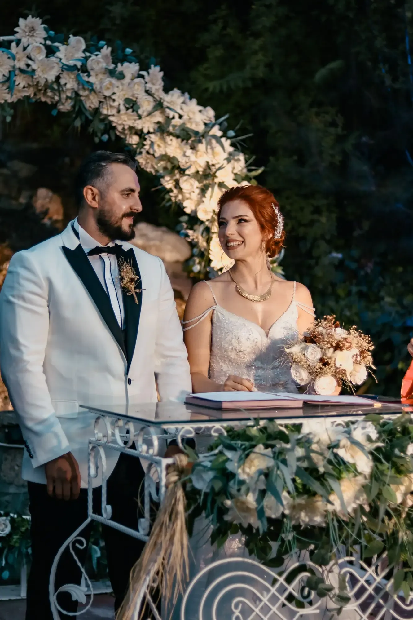 Charming outdoor wedding ceremony featuring a joyful bride and groom amidst beautiful floral decor.