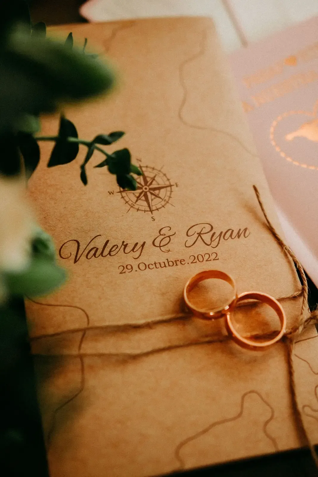 Elegant rustic wedding invitation featuring rings and floral decor, perfect for celebrations.