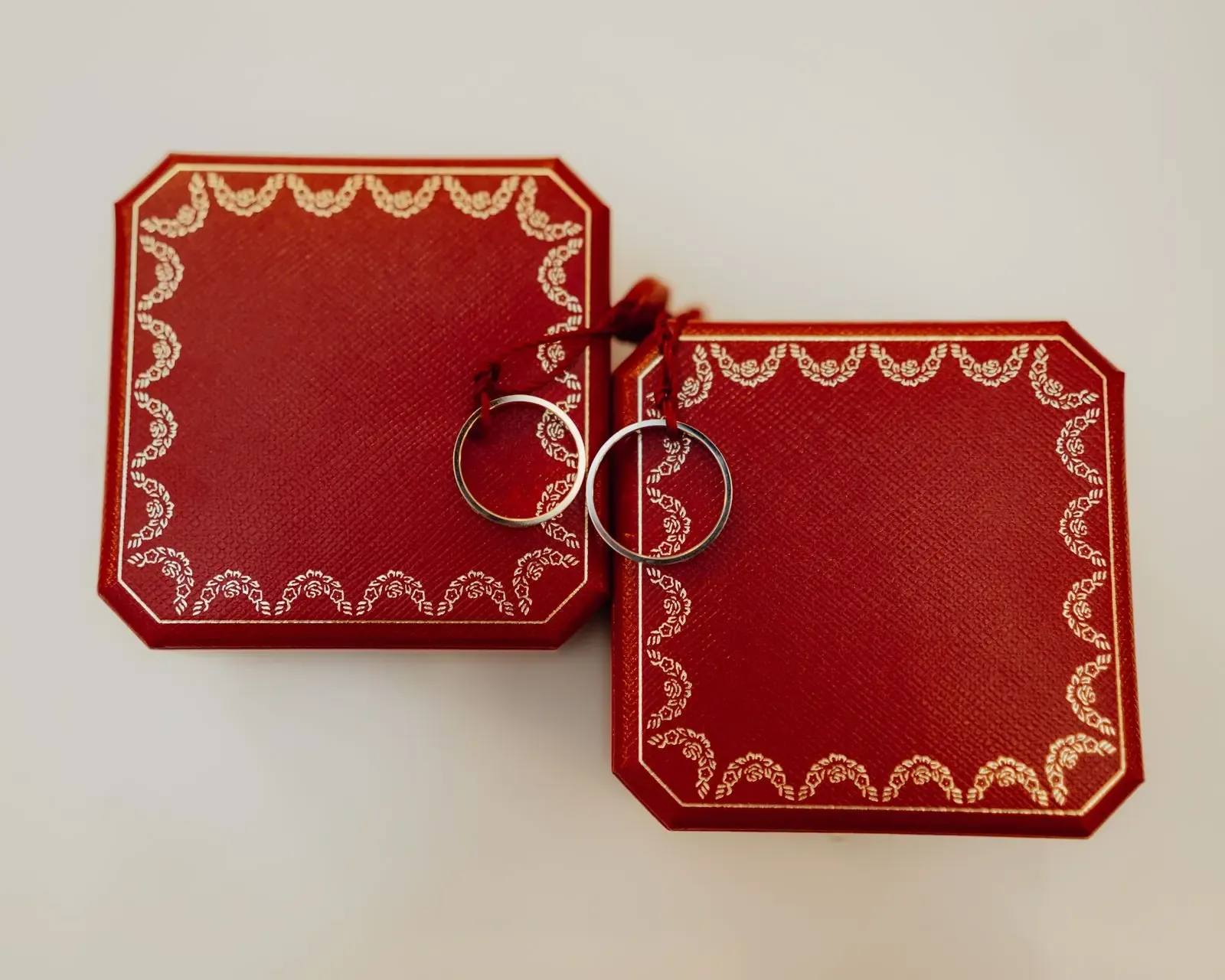 Two ornate red boxes with elegant silver rings, perfect for weddings or special occasions.