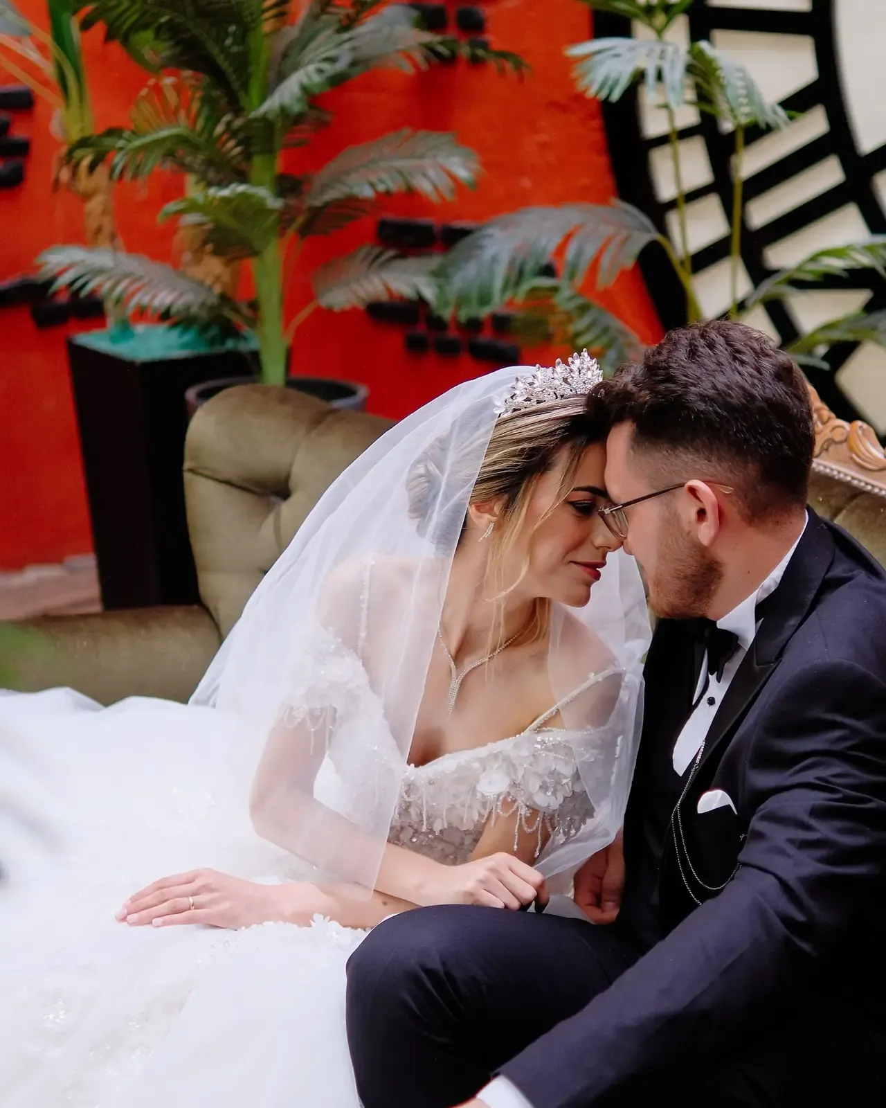 A newlywed couple smiling in front of mirrors, in black and white.