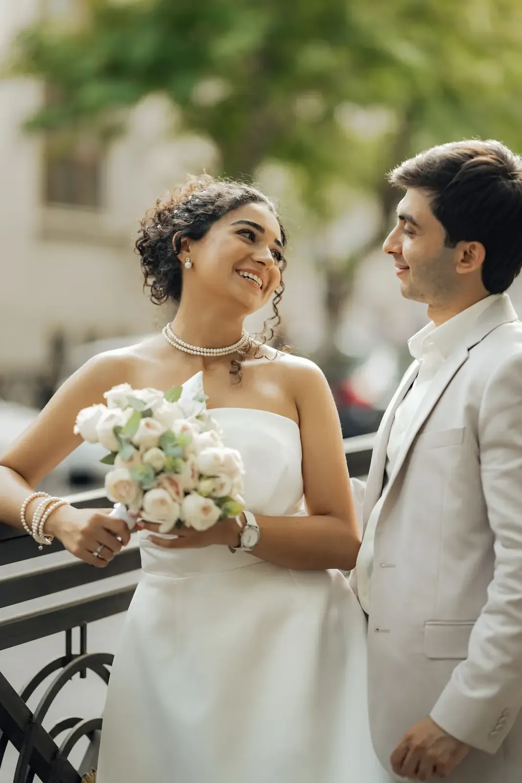 Happy bride and groom sharing a moment outdoors, embracing the joy of their wedding day.