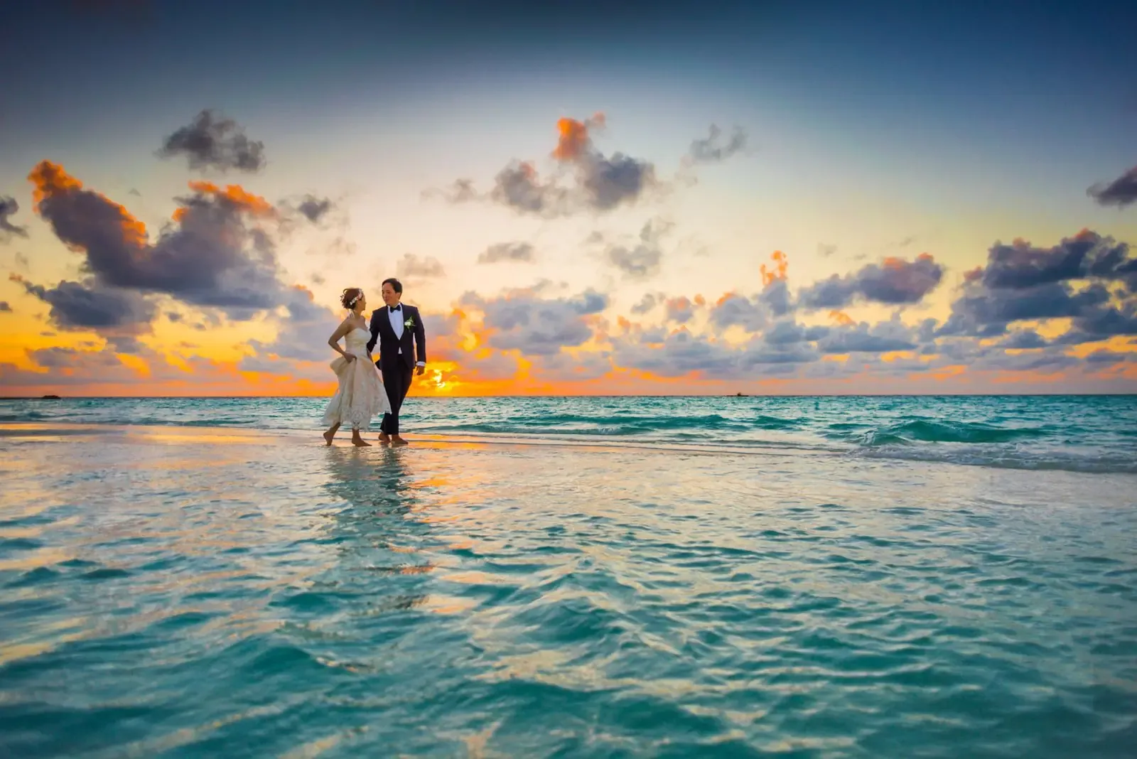 A couple on a beach at sunset.