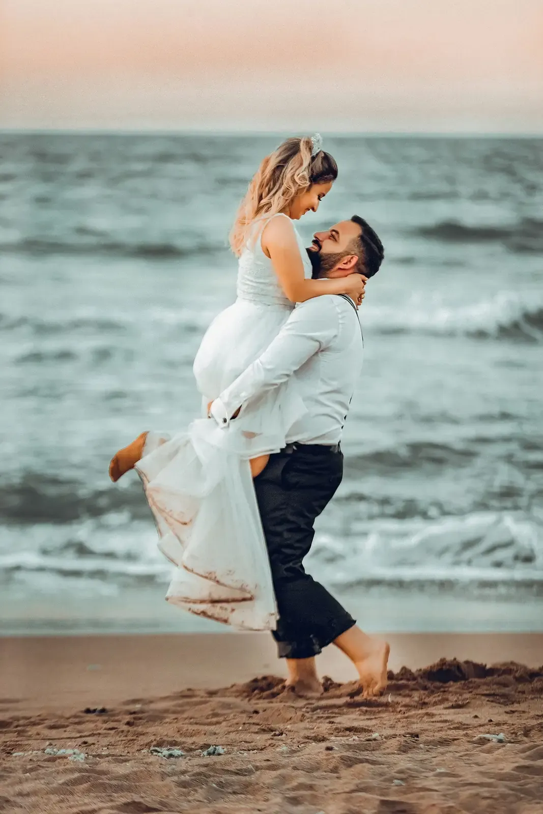 A joyful couple embraces on a Şile beach, capturing the essence of a romantic seaside wedding.
