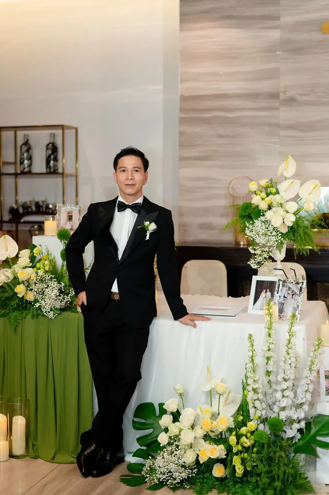 A groom poses confidently at a wedding reception in Phước Lý, Việt Nam.