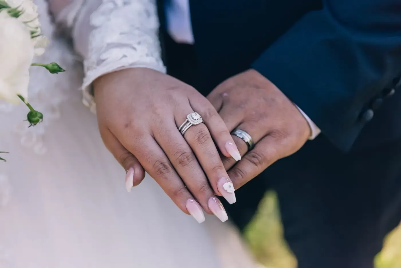 A couple's hands, close, wearing their wedding rings.