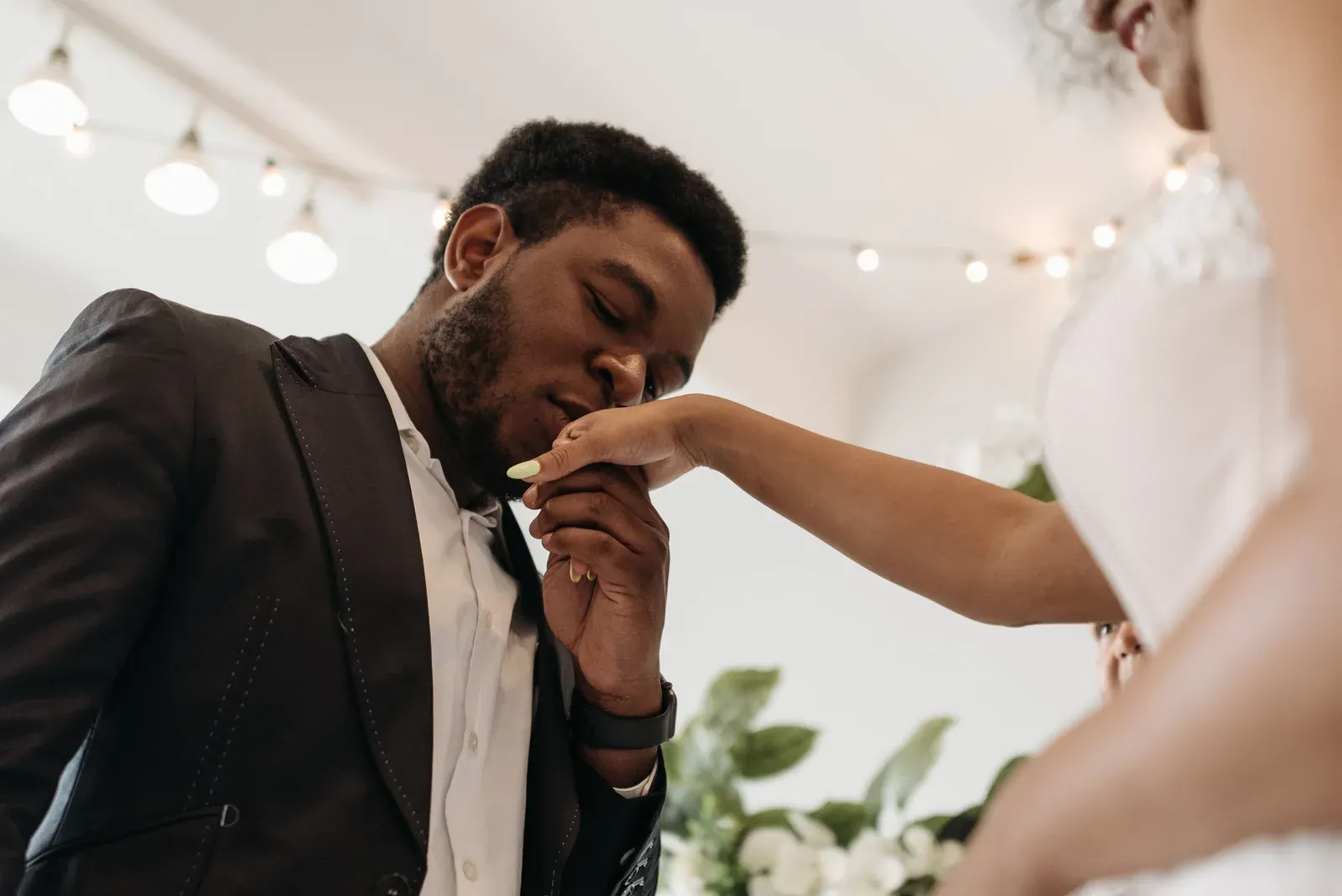 The groom kissing the bride's hand.