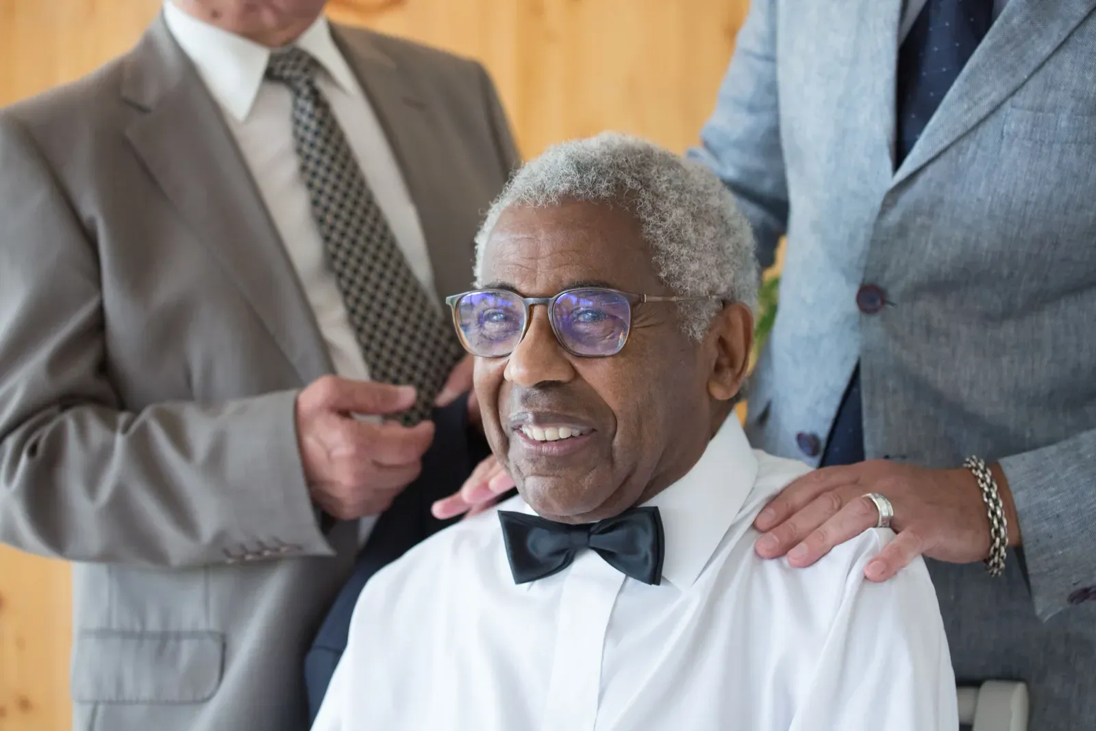 An older guest in a bow tie and glasses, laughing.