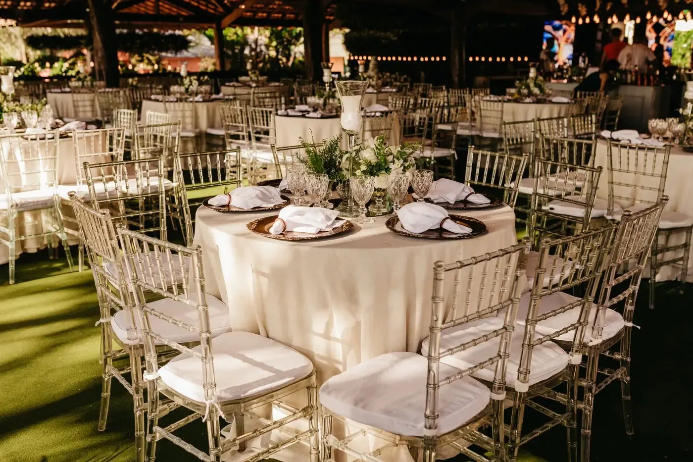 Chic outdoor wedding reception with elegant table setup and floral arrangements.